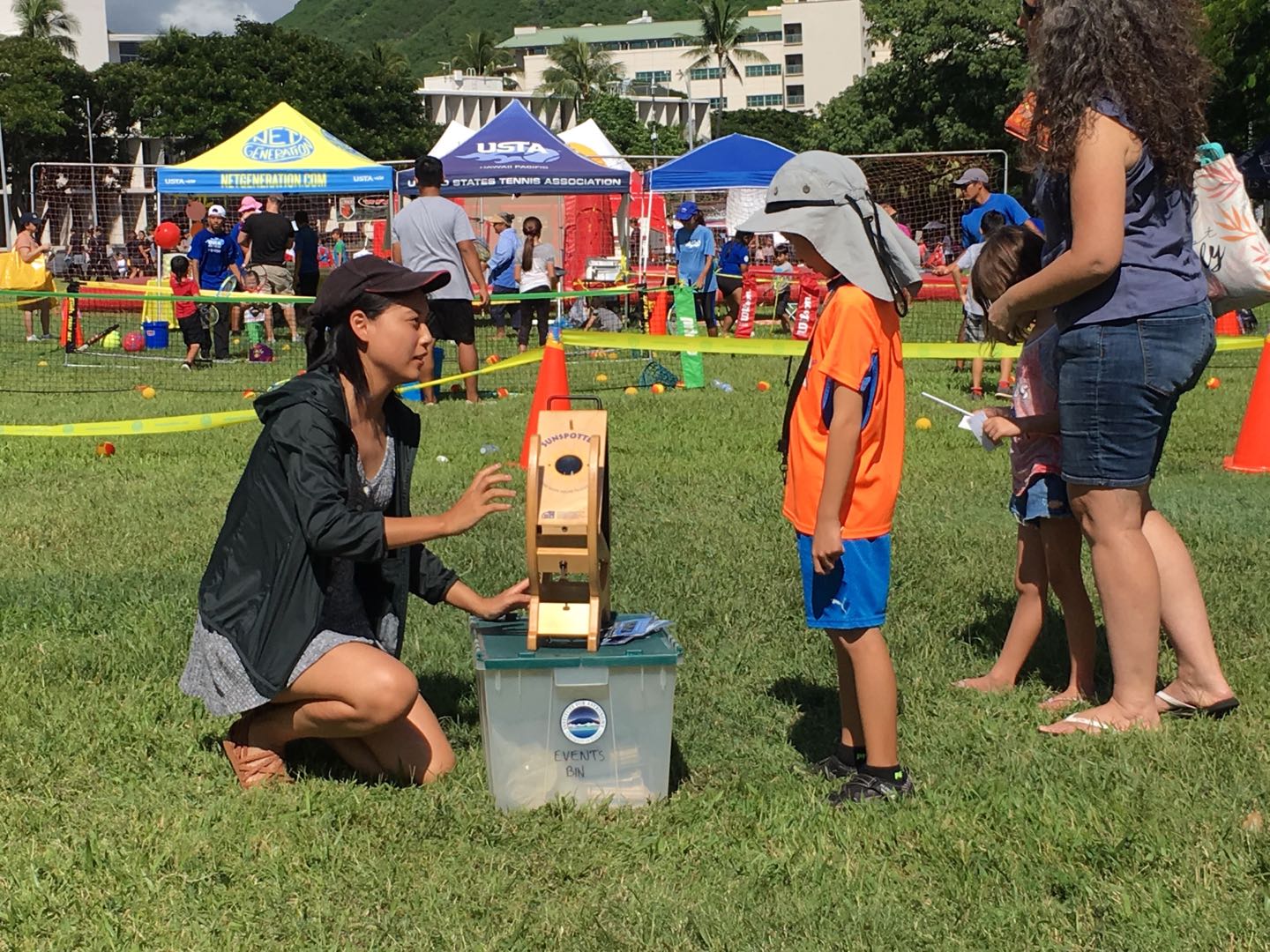 Jingwen speaking with a child during an outdoor outreach event.
